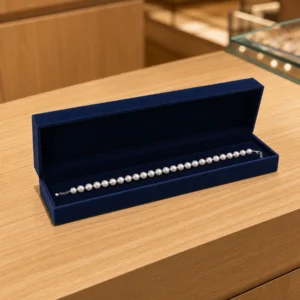 Navy velvet pearl necklace box displayed on a boutique counter Navy velvet pearl necklace box displayed on a boutique counter