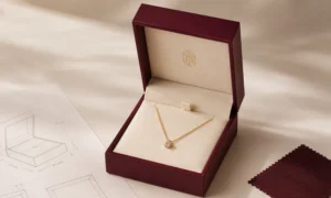 Burgundy necklace box beside packaging drawings and matching material swatches.