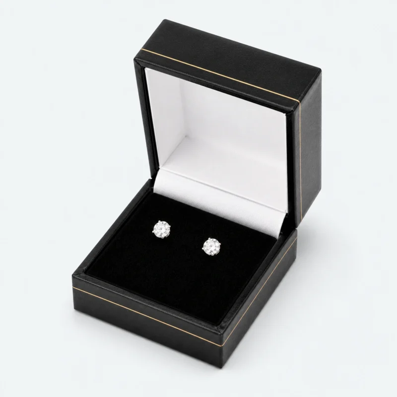 Open custom black leather hinged earring box with two stud earrings Open custom black leather hinged earring box with two stud earrings