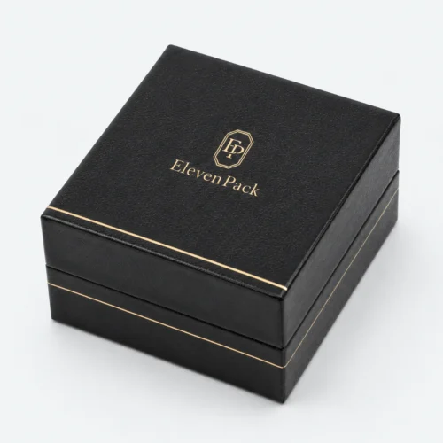 Closed black leather earring box with centered gold logo and trim