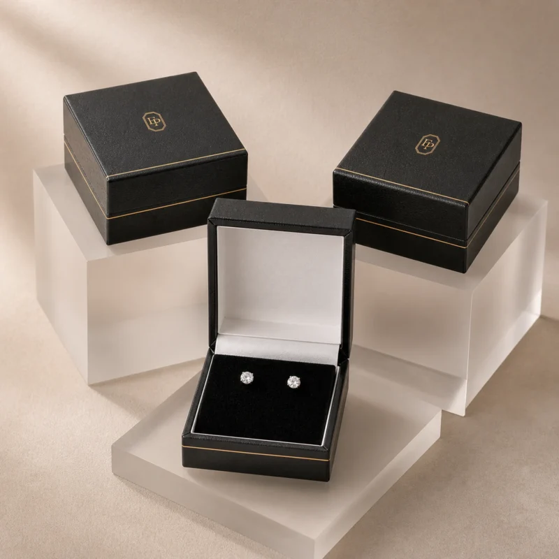 Coordinated black leather earring box packaging system on acrylic risers Coordinated black leather earring box packaging system on acrylic risers