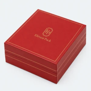 Closed red leather necklace box with centered gold logo and border