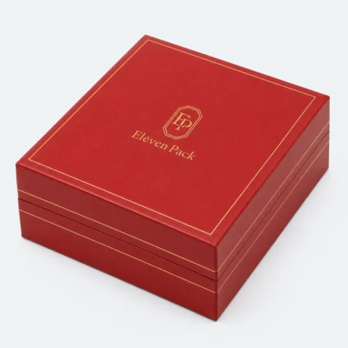 Closed red leather necklace box with centered gold logo and border