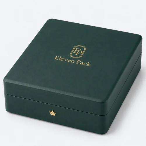 Closed green leather jewelry box with gold logo and crown-shaped closure