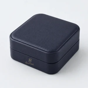 Closed dark blue leather bangle box with front panel gold logo