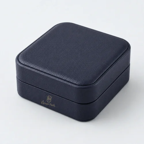 Closed dark blue leather bangle box with front panel gold logo