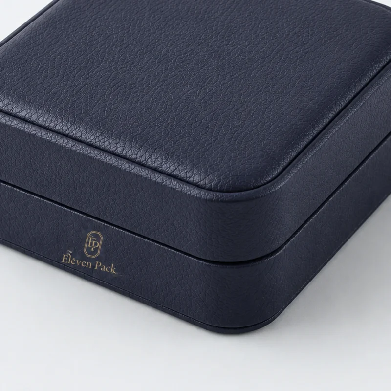Dark blue leather bangle box detail with front logo and rounded seam