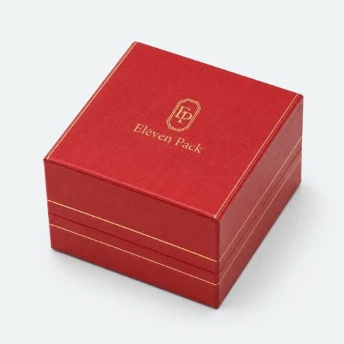 Closed custom red leather ring box with centered gold logo and trim