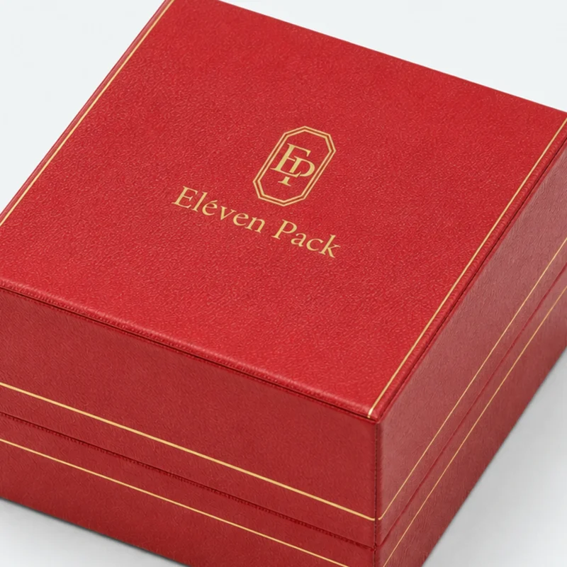 Red leather ring box detail showing gold edge trim and lid logo