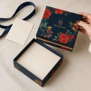Floral gift box being opened on warm wrapping paper