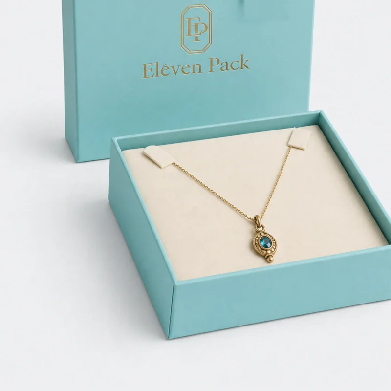 Cream necklace insert inside a turquoise paper gift box