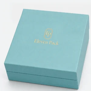 Close-up of gold Eleven Pack logo on a turquoise paper jewelry box lid