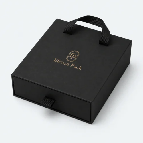 Closed black cardboard drawer jewelry box with ribbon handles and gold logo