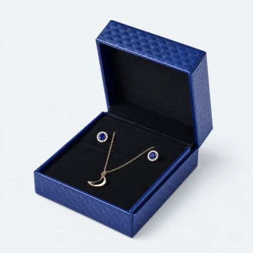 Open blue textured hinged jewelry box with necklace and earrings