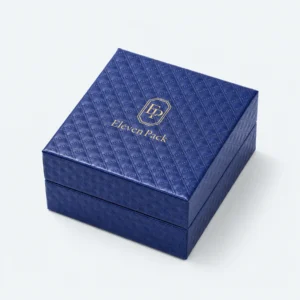 Closed blue cardboard jewelry box with quilted texture and gold logo