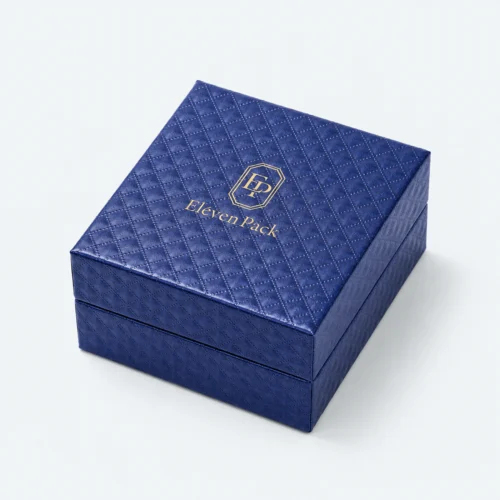 Closed blue cardboard jewelry box with quilted texture and gold logo