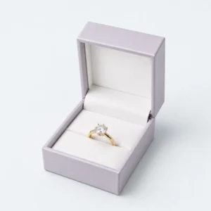 Open pale lilac hinged ring box with white insert and gold ring