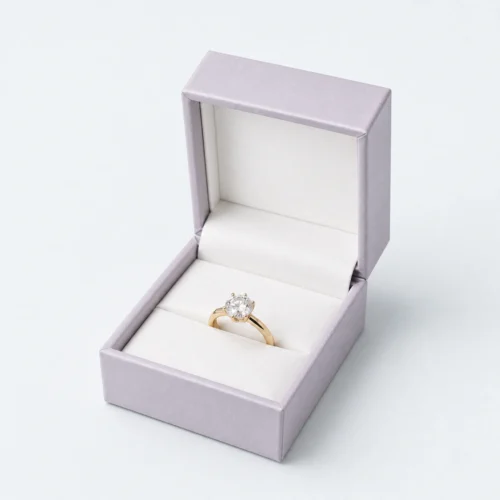 Open pale lilac hinged ring box with white insert and gold ring Open pale lilac hinged ring box with white insert and gold ring
