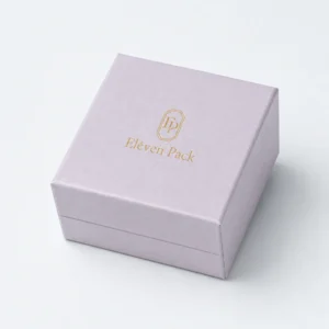 Closed pale lilac cardboard ring box with gold logo