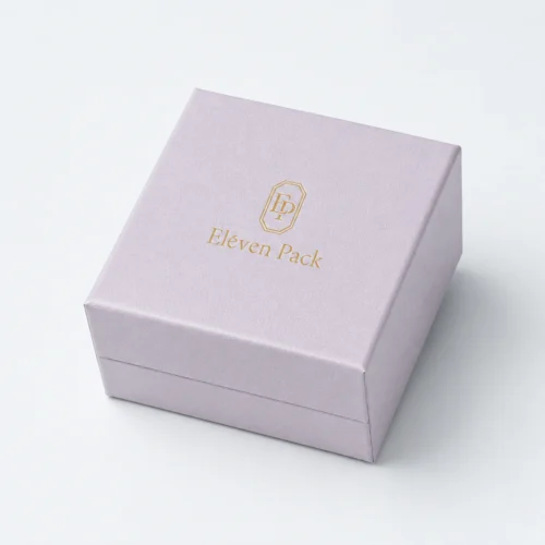Closed pale lilac cardboard ring box with gold logo