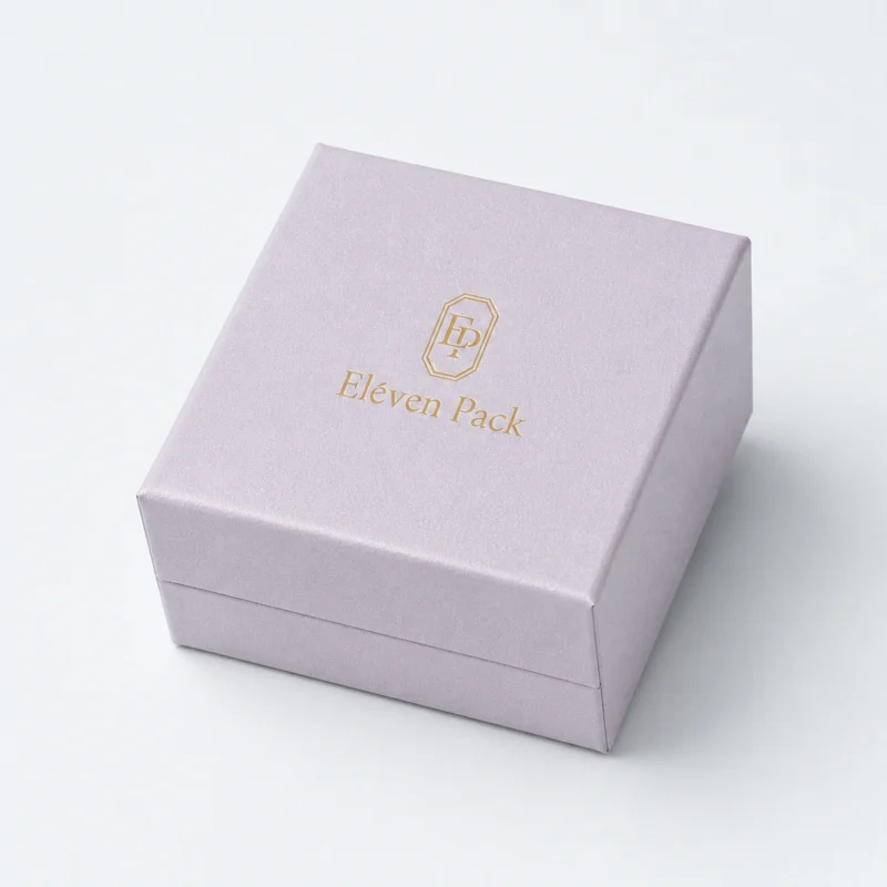 Closed pale lilac cardboard ring box with gold logo