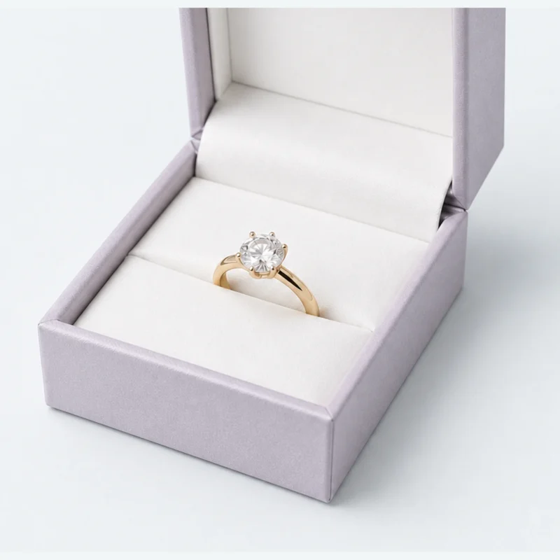 Close-up of a gold solitaire ring seated in the white insert slit