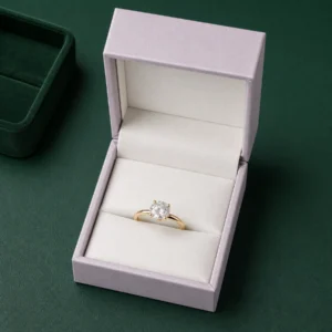 Pale lilac ring box on a dark green jewelry counter