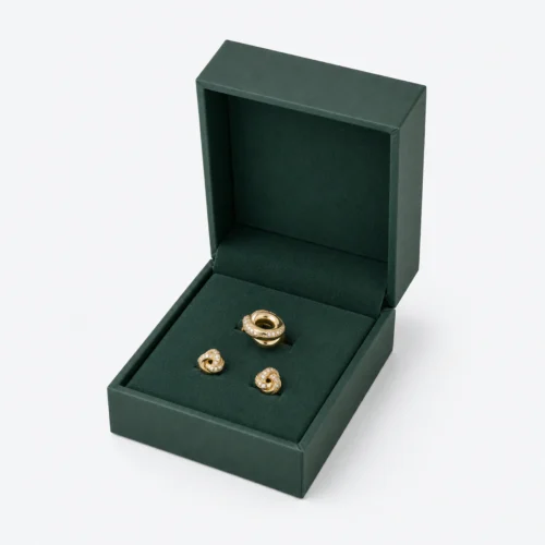 Open green hinged jewelry box with a ring and matching stud earrings