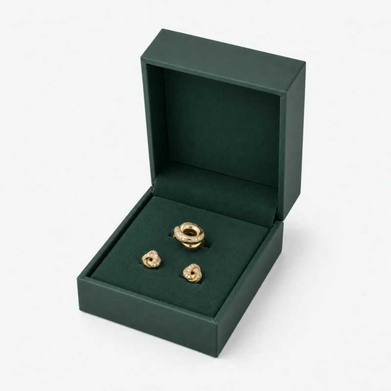 Open green hinged jewelry box with a ring and matching stud earrings