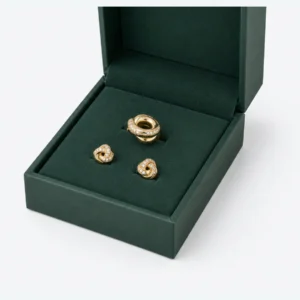 Close-up of a green insert holding a ring and stud earrings