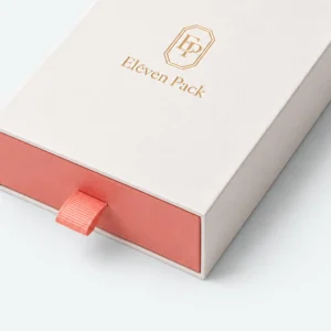 Close-up of coral drawer front, woven pull tab and white paper sleeve edge