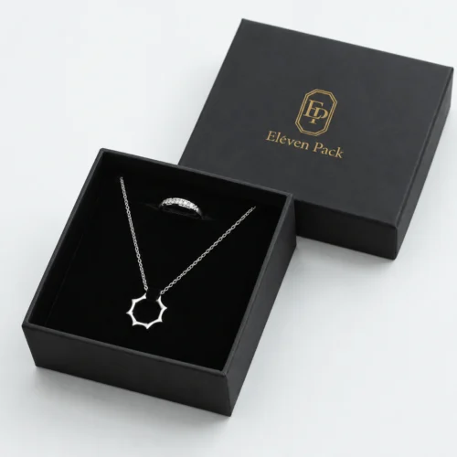 Open black cardboard necklace box with black velvet insert and matching branded lid
