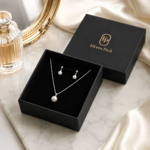 Black necklace box with pearl jewelry in a refined marble tabletop setting