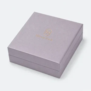 Closed gray lilac linen jewelry box with centered gold Eleven Pack logo