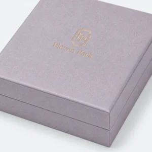 Close-up of gray lilac linen grain, gold foil logo and wrapped lid edge