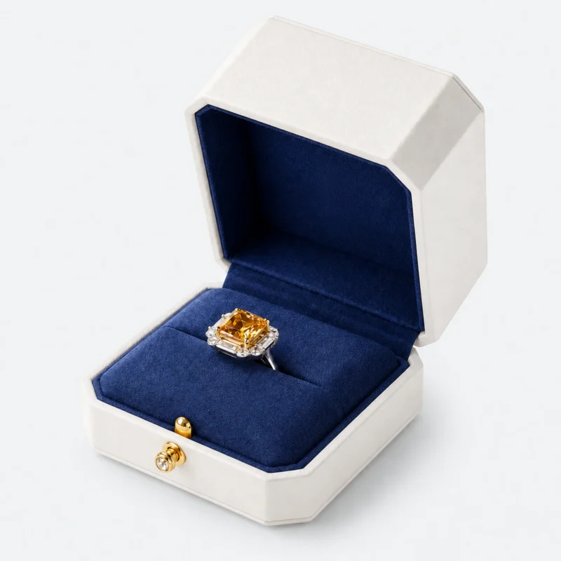 Open white leather ring box with blank navy lid and gemstone ring in the seam