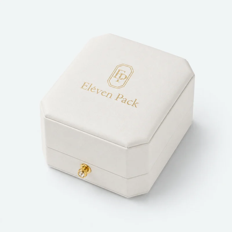 Closed white leather ring box with centered gold logo and front clasp