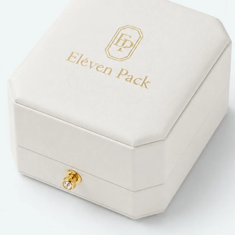 Close-up of white leather wrap, gold clasp and closed lid seam
