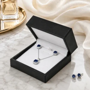 custom black pu leather necklace box image 05 usage scene JB-BM-05-P24 Open black PU leather necklace box in a premium marble and satin retail scene