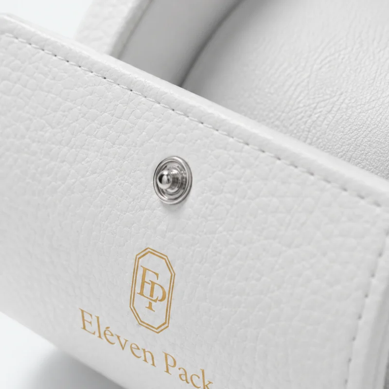 White leather watch box detail showing grain, stitching, snap and gold branding