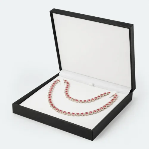 Open black necklace box with white fitted insert and red gemstone necklace