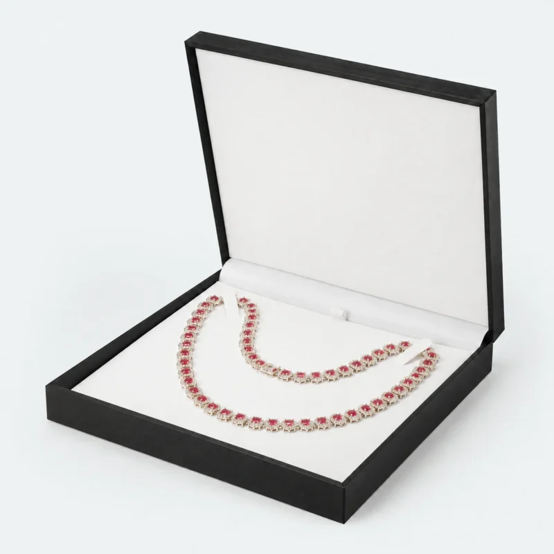 Open black necklace box with white fitted insert and red gemstone necklace