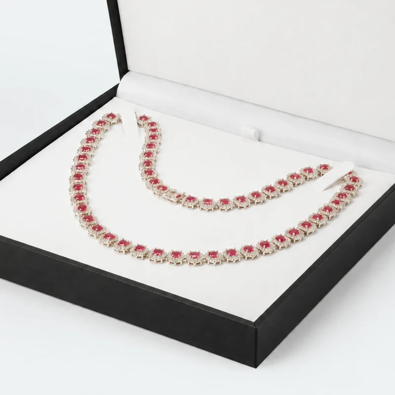 Close-up of white necklace insert and securing tabs in open black box