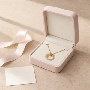 Dusty pink necklace presentation box styled with ribbon on pale stone