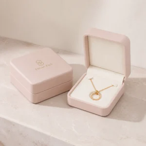 Matching dusty pink necklace boxes shown open and closed in soft daylight
