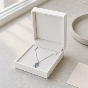 White necklace presentation box displayed in a refined jewelry showroom setting