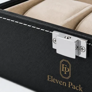 Close-up of centered silver clasp, white stitching and gold logo on black watch box