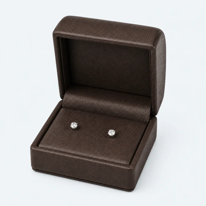 Open brown genuine leather earring box with stud earrings displayed inside