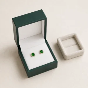 Dark Green PU Leather Earring Box - Usage Scene Dark green PU leather earring box with green stud earrings in a retail presentation scene
