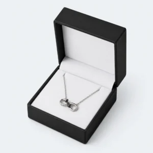 Open black and white PU leather necklace box with silver necklace displayed inside